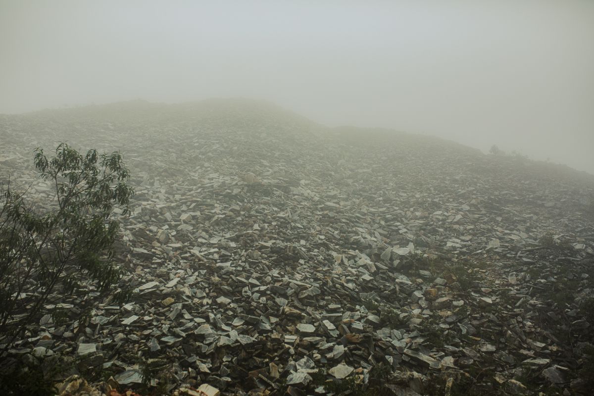 Dense fog rolling over a desolate, rocky coastal landscape, illustrative photo