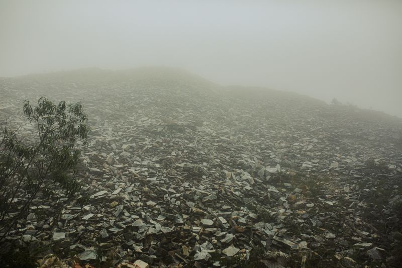 Dense fog rolling over a desolate, rocky coastal landscape, illustrative photo