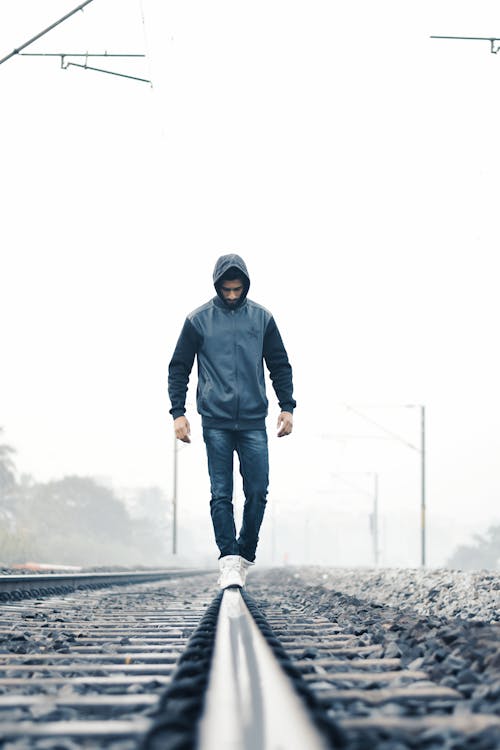 Free Man Walking on Train Rail Stock Photo