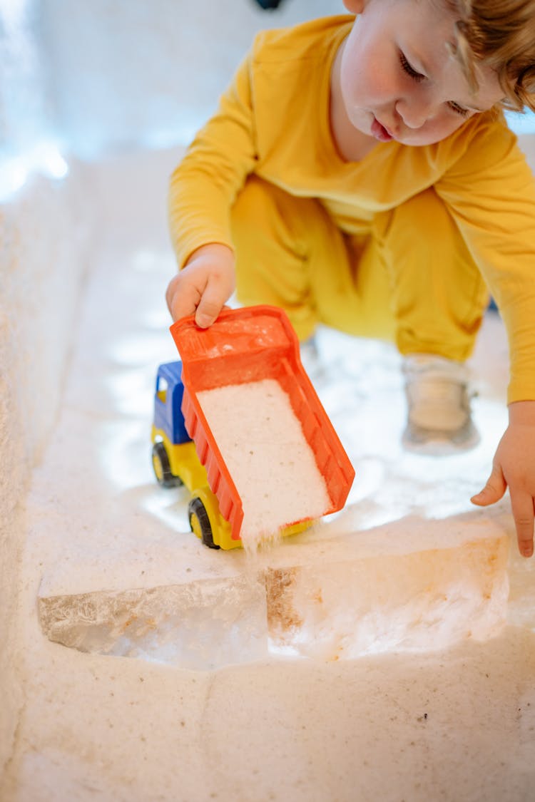 A Boy Playing With A Toy Truck