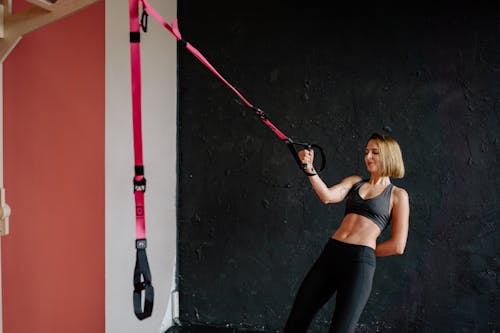 Free A Woman in Sportswear Exercising with a Suspension Trainer Stock Photo