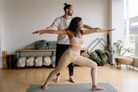 A Man and Woman Doing Yoga while Standing on a Yoga Mat