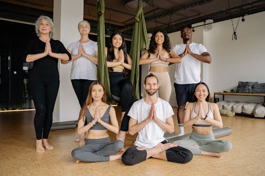 A diverse group of adults practicing yoga together indoors, focusing on mindfulness and flexibility.