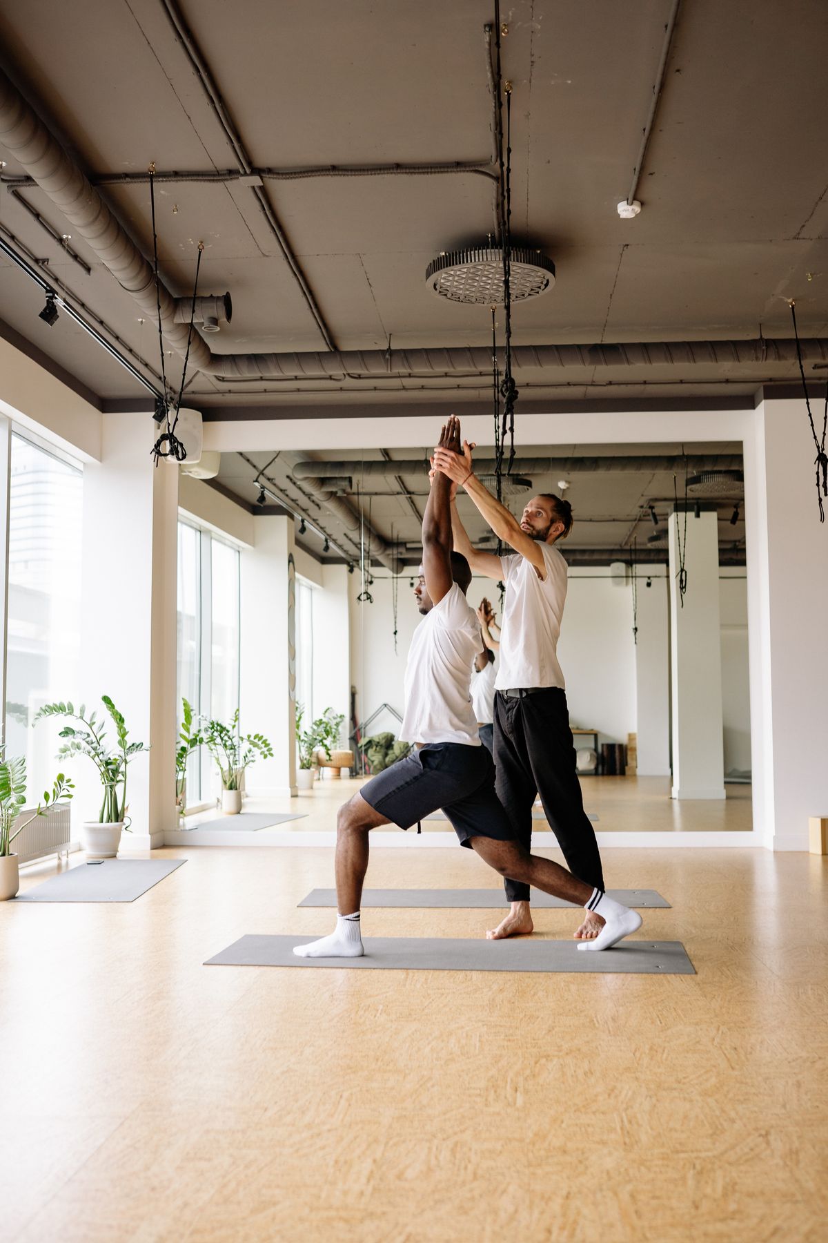 Yoga instructor teaching student in a studio