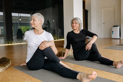 Two senior women enjoying yoga, focusing on wellness and flexibility indoors.
