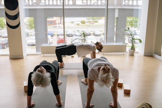 Senior adults in a yoga class practicing reverse table pose in a serene studio.