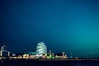 夜空中，一座发光的摩天轮矗立在充满活力的游乐园里