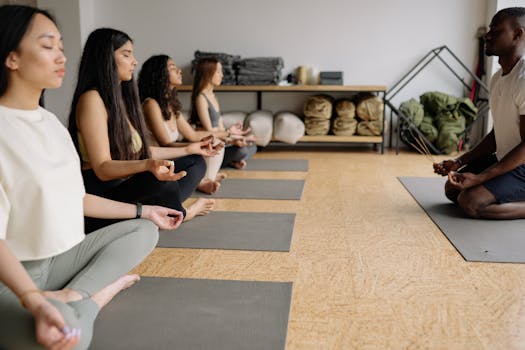 A multicultural yoga class practicing meditation and mindfulness indoors.
