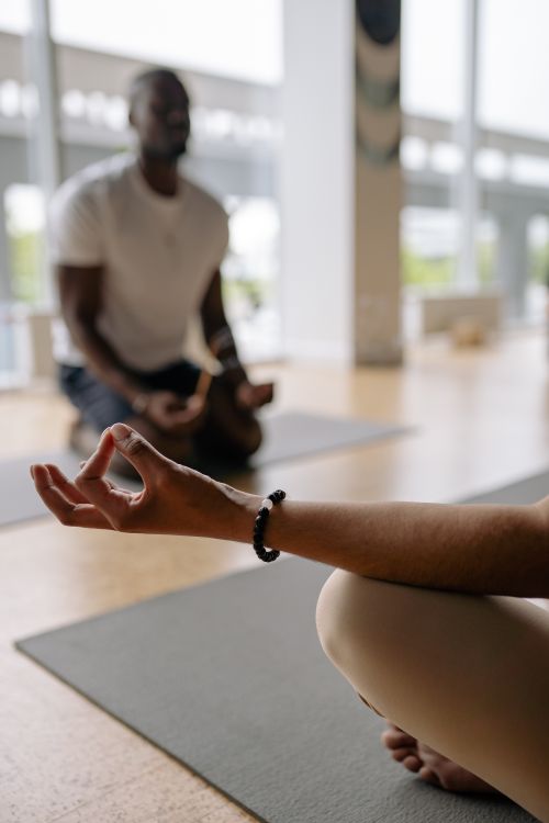 Free A serene indoor yoga meditation session focusing on hand gestures and blurred background. Stock Photo
