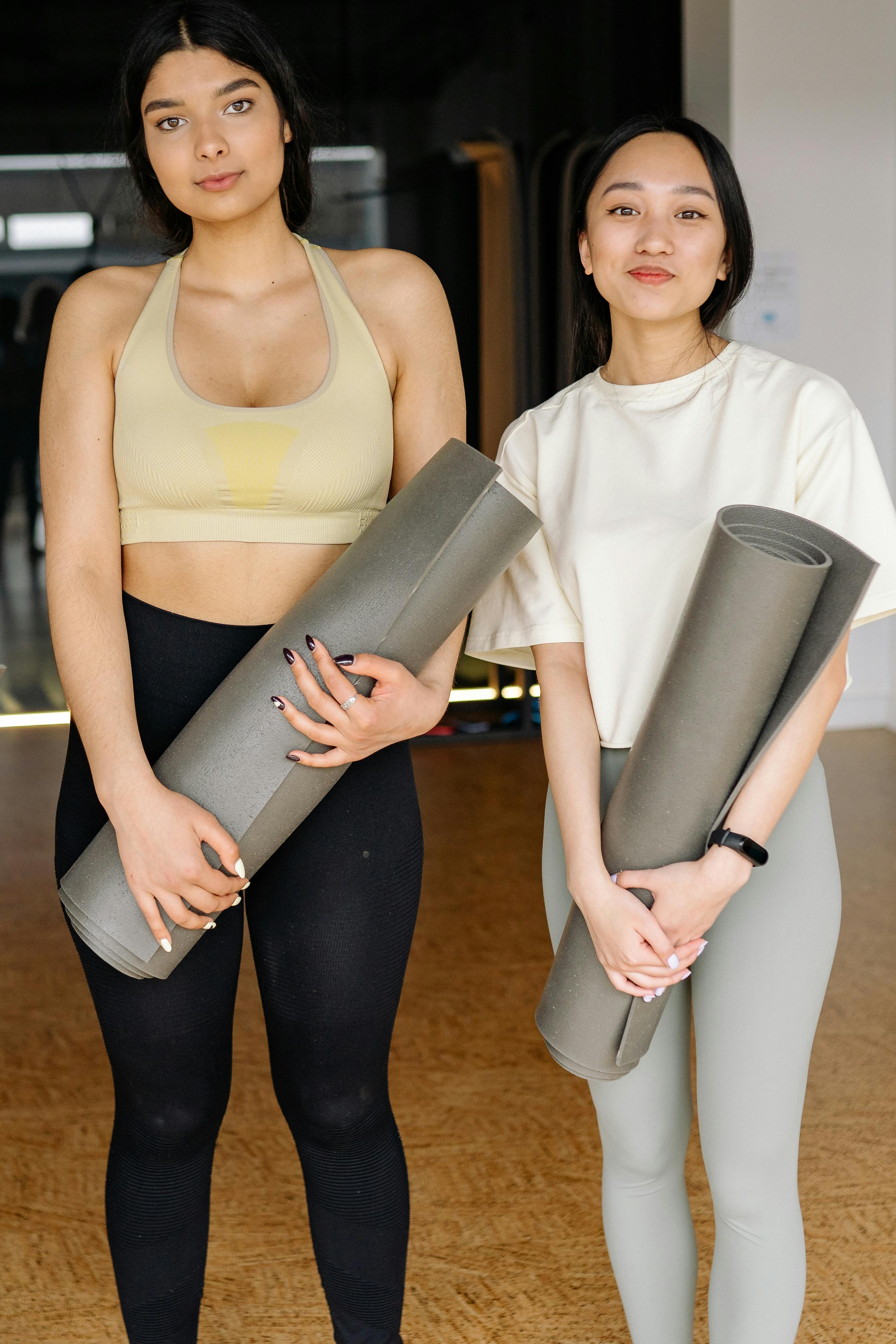 A Woman in Beige Tank Top Carrying a Rolled Yoga Mat · Free Stock