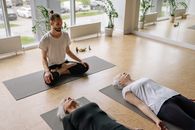 Man in White Crew Neck T-shirt and Black Pants Doing Yoga