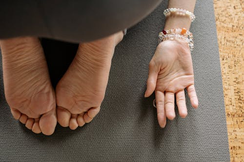 A Close-Up Shot of a Person's Feet and Hand