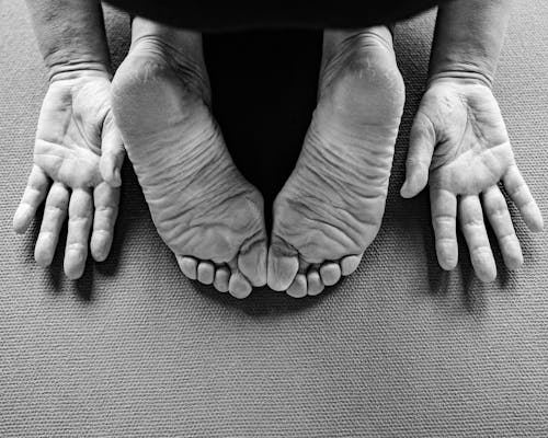 
A Grayscale of a Person's Hands and Feet