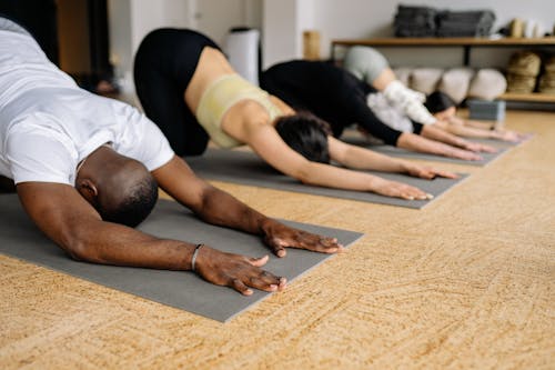 Free Man in White Shirt Doing Stretching in Yoga Class Stock Photo