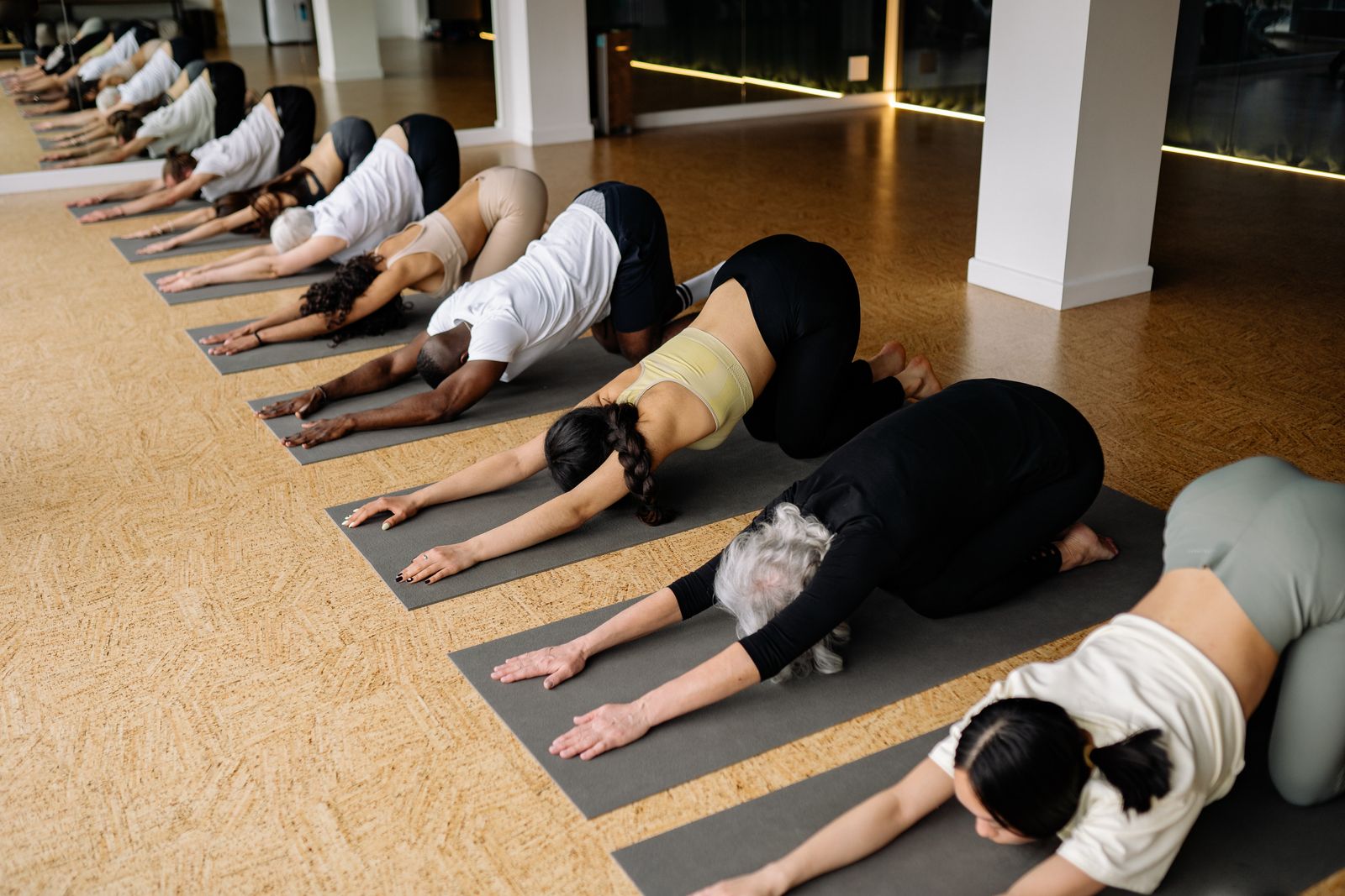 Group of people practicing yoga poses together in a studio class