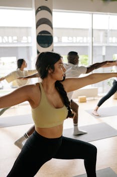 A diverse group of adults practicing yoga in a bright, modern studio, focusing on alignment and balance.