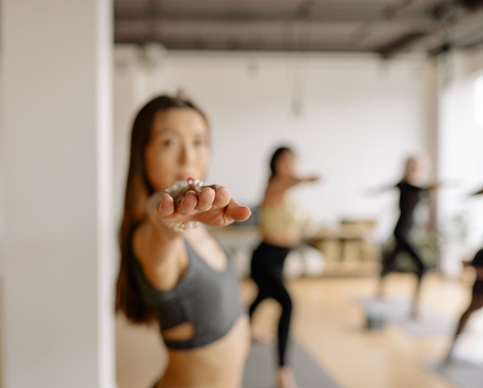 Woman practicing warrior pose during a group yoga class indoors