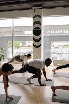 A diverse group of adults practicing yoga poses indoors, promoting fitness and wellness.