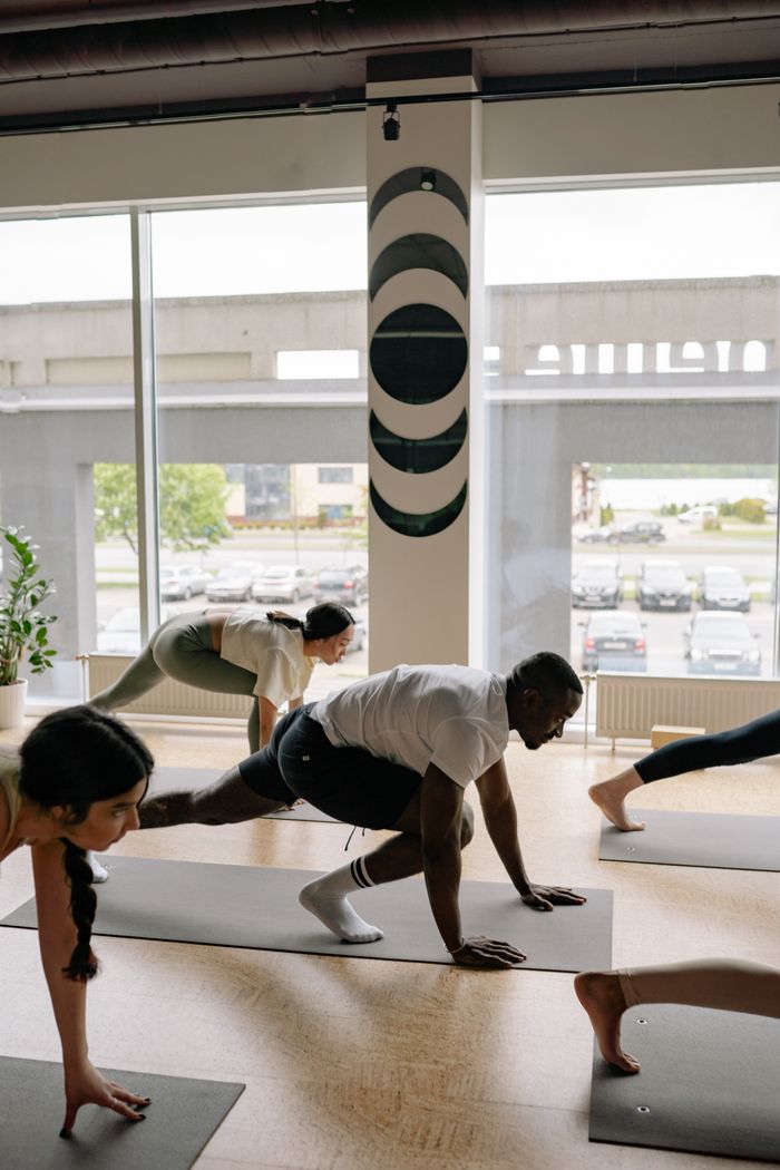 Group yoga class holding a pose indoors — photo by Yan Krukau on Pexels