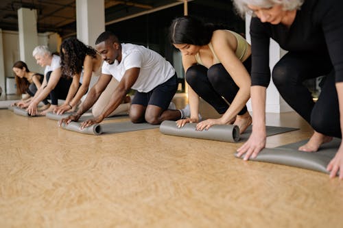 Men and Women Rolling Yoga Mats on the Floor