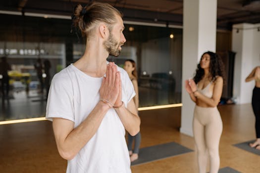 Group of adults practicing yoga in a calm studio setting, focusing on mindfulness and wellness.