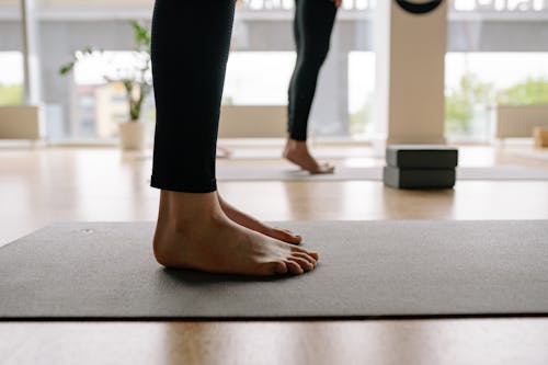 Woman Wearing Black Leggings Standing on Yoga Mat