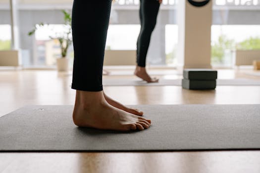 Close-up of feet on a yoga mat during a class, emphasizing balance and mindfulness.