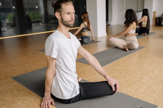 Yoga class with individuals meditating indoors, focusing on well-being and relaxation.