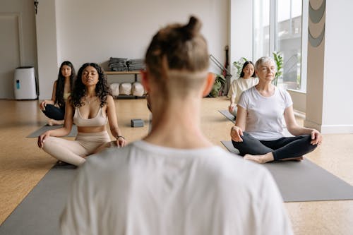 Free Selective Focus of People Meditating in a Yoga Class Stock Photo