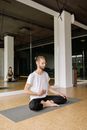 Man in White Crew Neck T-shirt and Black Pants Sitting on Floor