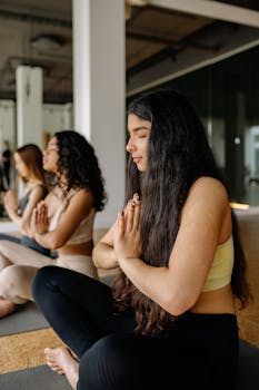 Group of women meditating in yoga class with peaceful ambiance.