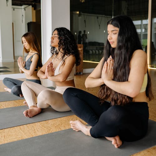 Free Women Meditating in a Yoga Class Stock Photo
