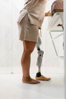 Close-up of woman with prosthetic leg standing in bathroom, reflecting modern technology and empowerment.