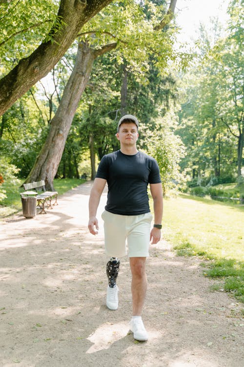 Free A Man in Black Shirt Walking at the Park Stock Photo