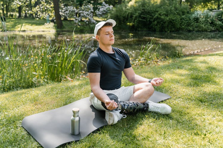 A Man In Black Shirt Doing Yoga At The Park