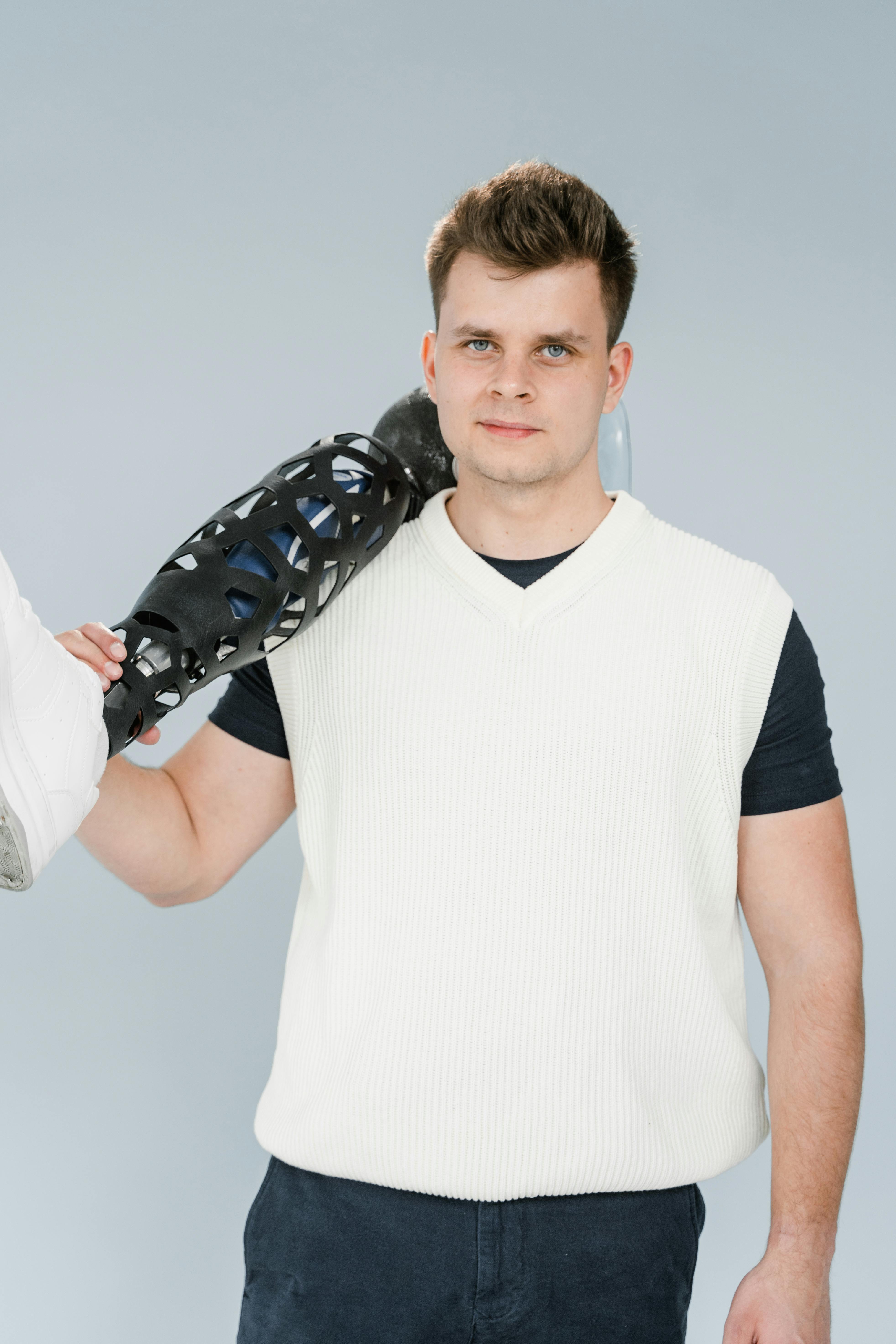 A strong man confidently holds a futuristic prosthetic leg, symbolizing innovation and empowerment.