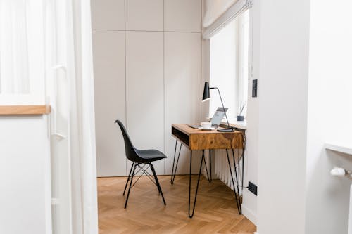 Darmowe zdjęcie z galerii z biuro domowe, czarne krzesło, drewniany stół