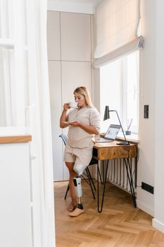 Woman in White Tank Top and White Shorts Standing Beside Brown Wooden Table