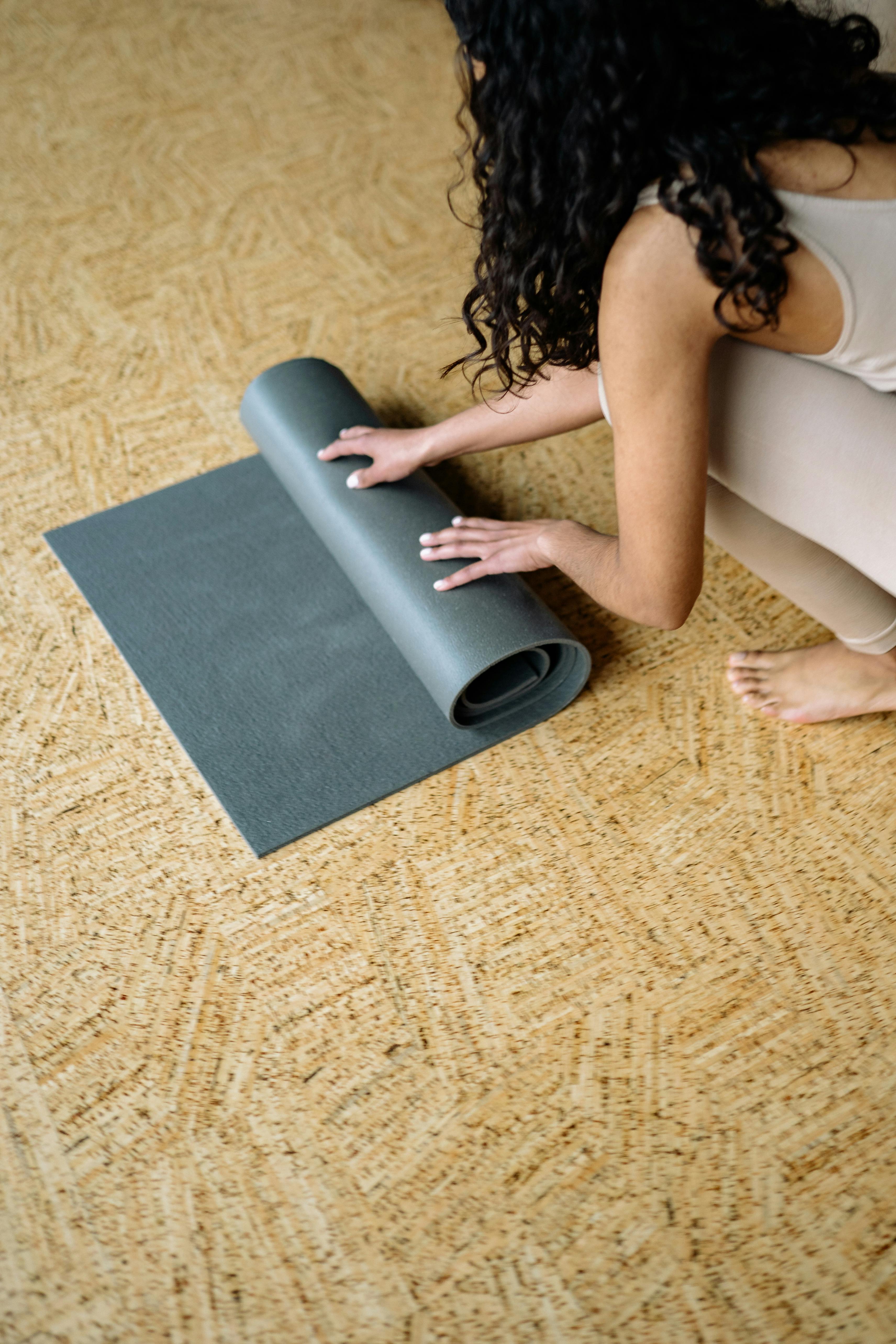 A Woman in Beige Tank Top Carrying a Rolled Yoga Mat · Free Stock