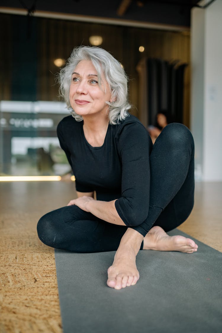 An Elderly Woman On A Yoga Mat 