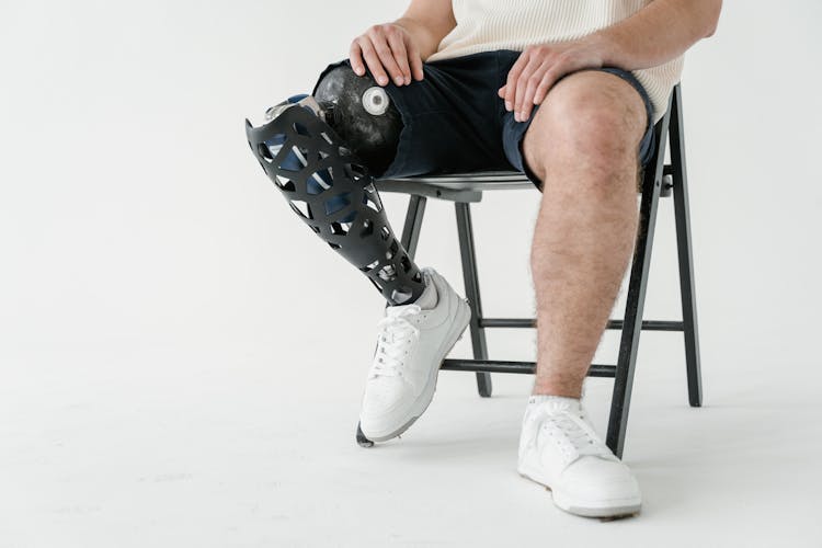 A Man Wearing White Shoes Sitting On Chair