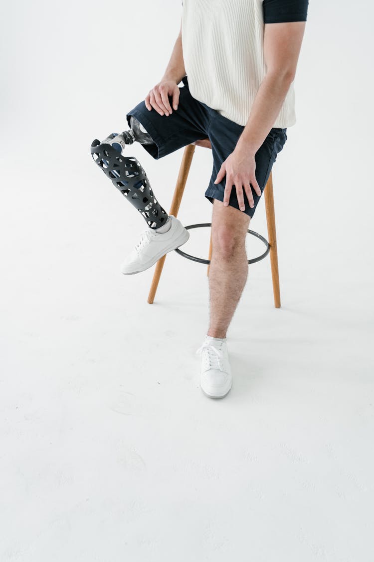 A Man Wearing White Shoes Sitting On Stool