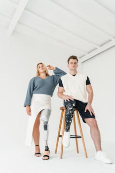 Portrait of a man and woman with prosthetic legs in a bright indoor setting.