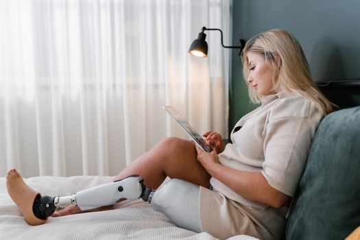 Woman sitting on Bed While Holding a Tablet