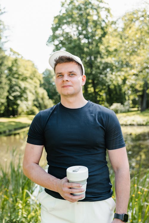 Free Portrait of a Man in Black Shirt Holding a Tumbler Stock Photo
