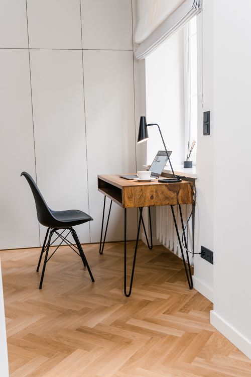 Free Bright minimalist home office with modern wooden desk, chair, and natural light. Stock Photo