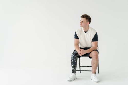 
A Man with a Prosthetic Leg Sitting on Chair