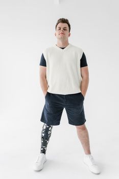 Portrait of a man with a prosthetic leg standing confidently in a bright studio.