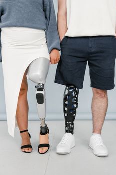 A man and woman in stylish outfits, each with a prosthetic leg, showcasing body positivity and inclusivity.