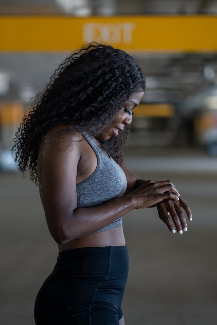 Woman In A Gray Sports Bra Looking At The Time